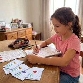 Criança fazendo atividade com flashcards de inglês